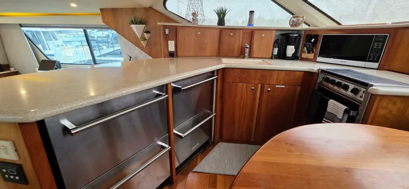  Yacht Photos Pics Luxurious kitchen interior of 2000 Silverton 453MY yacht with modern appliances and wood cabinetry.