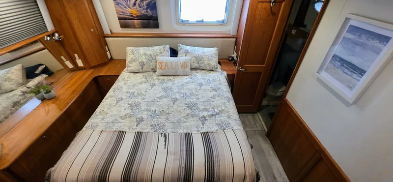  Yacht Photos Pics Cozy bedroom in 2000 Silverton 453MY yacht with nautical decor and wooden furnishings.