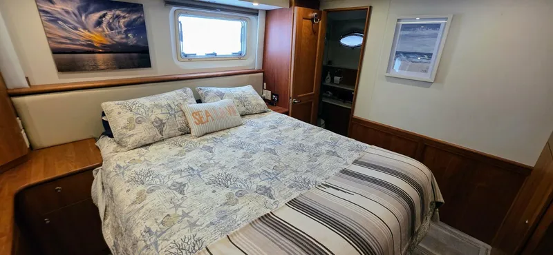  Yacht Photos Pics Cozy bedroom interior of 2000 Silverton 453MY yacht with nautical decor and window view.