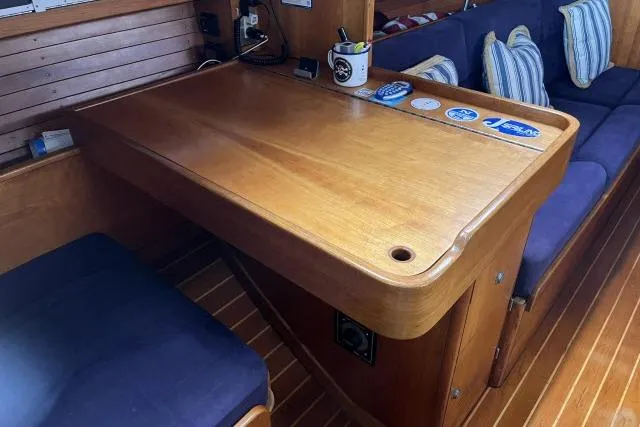 G Force Yacht Photos Pics Interior of 2004 J Boats J/133 yacht with wooden table and blue seating.