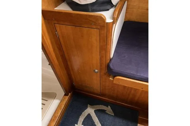G Force Yacht Photos Pics Interior of 2004 J Boats J/133 with wooden cabinet and navy cushion.