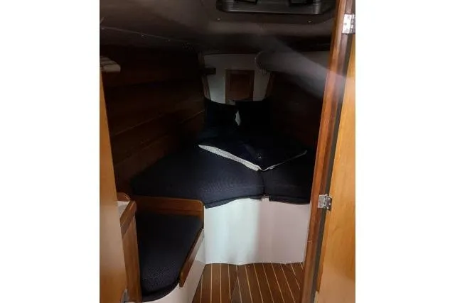 G Force Yacht Photos Pics 2004 J Boats J/133 cabin interior with wooden finish and cozy bedding.