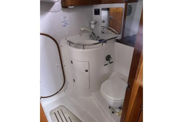 G Force Yacht Photos Pics 2004 J Boats J/133 yacht bathroom with sink, toilet, and wooden accents.