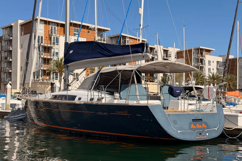 Gazelle II Yacht Photos Pics 2015 Beneteau Oceanis Yacht 60 docked in a marina, modern buildings in background.