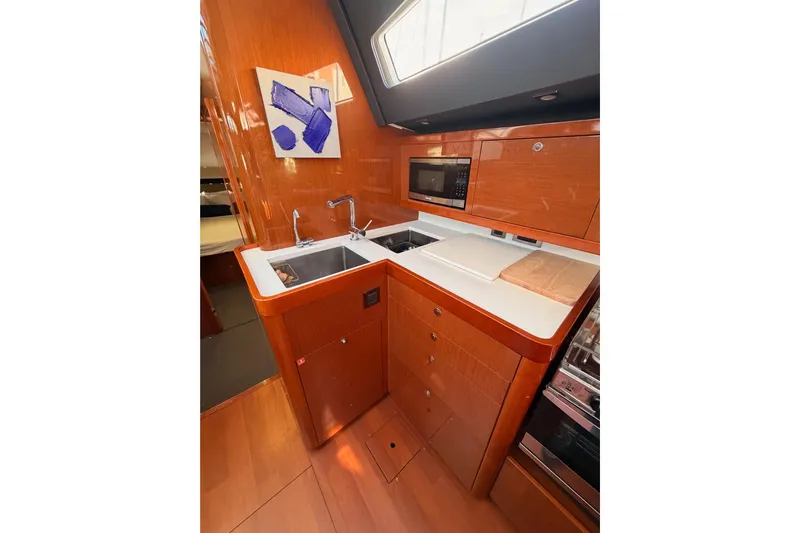 Gazelle II Yacht Photos Pics Modern kitchen interior of 2015 Beneteau Oceanis Yacht 60 with wood finish and appliances.