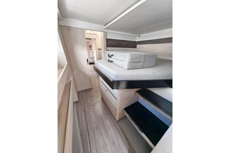 Old Marblehead Yacht Photos Pics Modern interior of 2019 Leopard 50 yacht with sleek wooden cabinetry and compact sleeping area.