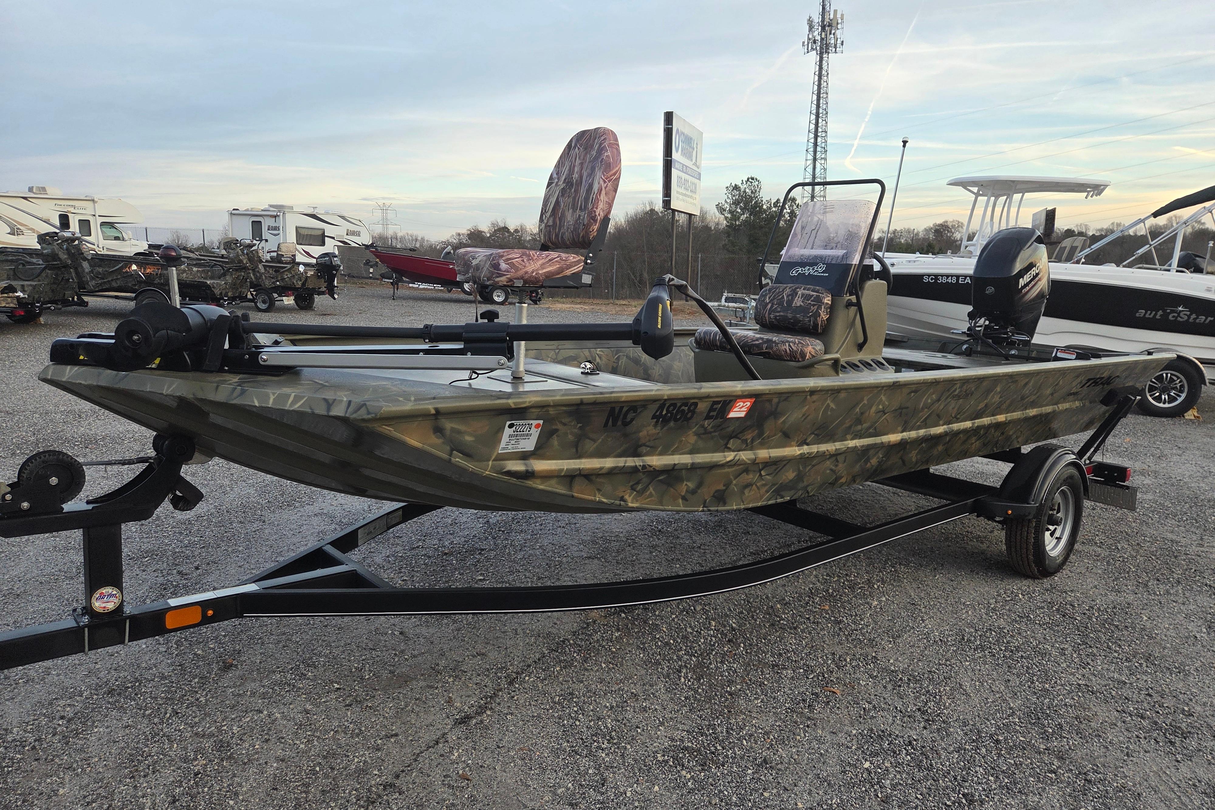 2018 Tracker Grizzly 1860 CC boat on trailer, camo design, parked outdoors.
