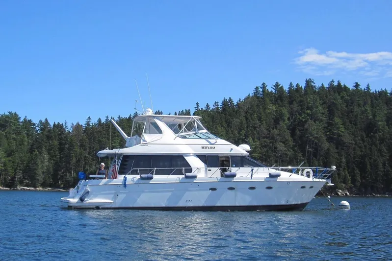 Betty Jean Yacht Photos Pics 2000 Carver 530 Voyager Pilothouse yacht on serene water, forested background.