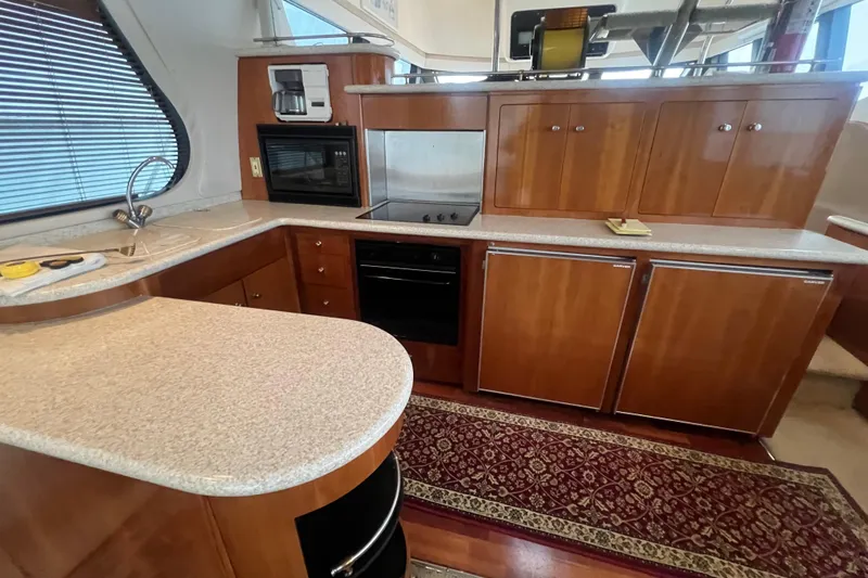 Betty Jean Yacht Photos Pics Luxurious kitchen in 2000 Carver 530 Voyager Pilothouse with wood cabinetry and modern appliances.