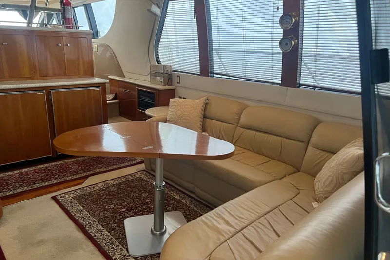 Betty Jean Yacht Photos Pics Luxurious interior of 2000 Carver 530 Voyager Pilothouse with leather seating and wooden table.