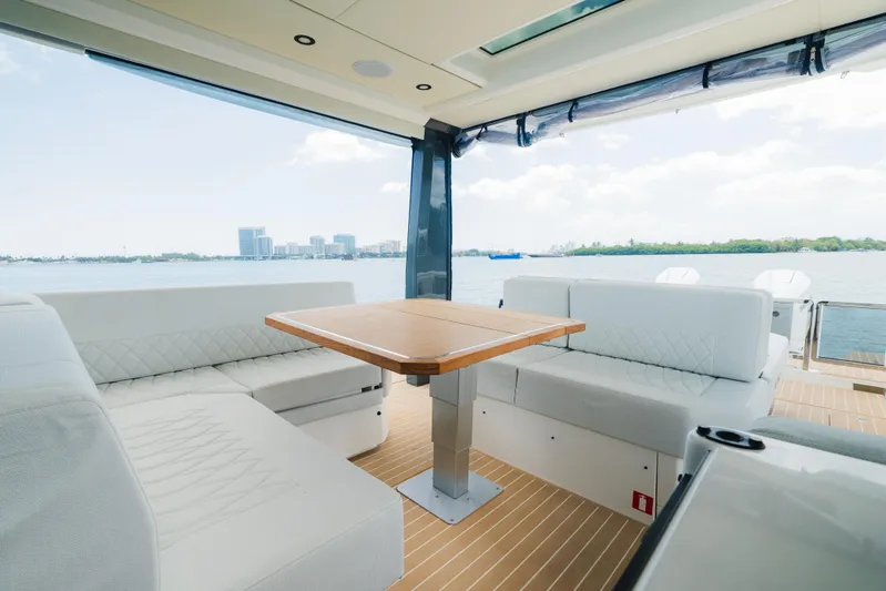La Plage Yacht Photos Pics 2024 Saxdor 400 GTO interior with modern seating and table, overlooking a scenic waterfront.
