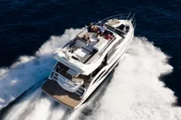 2025 Galeon 480 Fly yacht cruising on open water, aerial view.