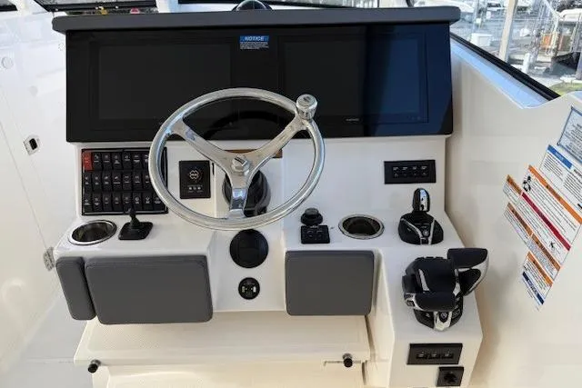  Yacht Photos Pics 2025 Pursuit DC 365 Dual Console boat dashboard with steering wheel and control panel.
