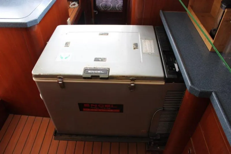 Mangata Yacht Photos Pics Engel refrigerator in 2003 Lagoon 43 PC yacht interior, featuring wooden flooring and countertops.