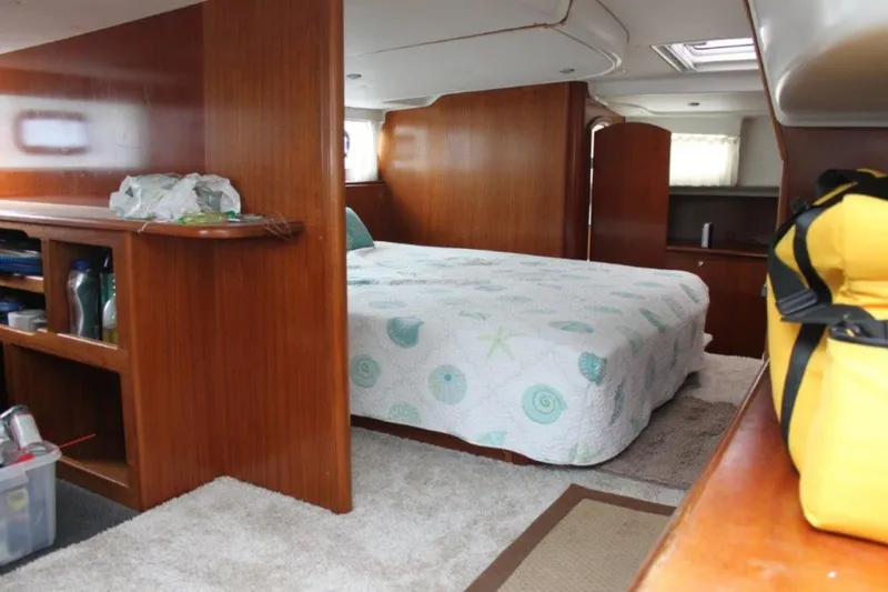 Mangata Yacht Photos Pics Interior of 2003 Lagoon 43 PC yacht with cozy bedroom and wooden furnishings.
