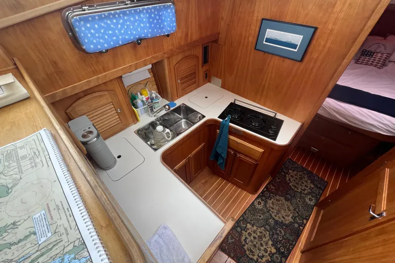 Semper Fi Yacht Photos Pics 2004 Sabre 36 Hardtop Sedan interior with compact kitchen and wooden cabinetry.