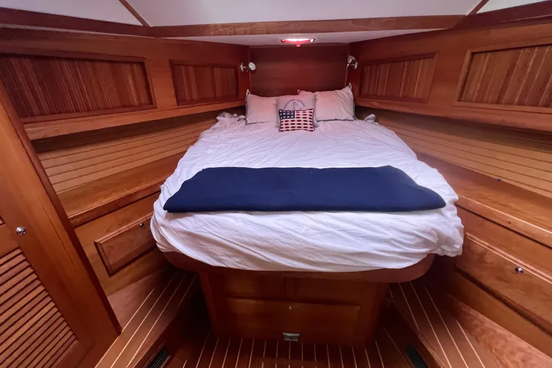 Semper Fi Yacht Photos Pics Cozy cabin interior of 2004 Sabre 36 Hardtop Sedan with wooden paneling and comfortable bedding.