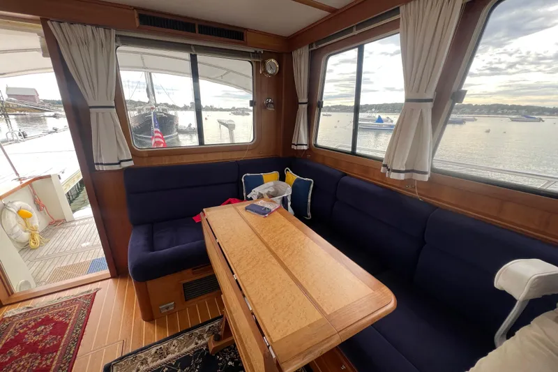 Semper Fi Yacht Photos Pics Interior of 2004 Sabre 36 Hardtop Sedan with blue seating and wooden table.