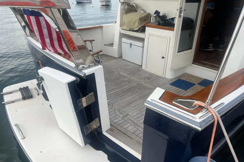 Semper Fi Yacht Photos Pics 2004 Sabre 36 Hardtop Sedan boat with American flag, docked on calm water.