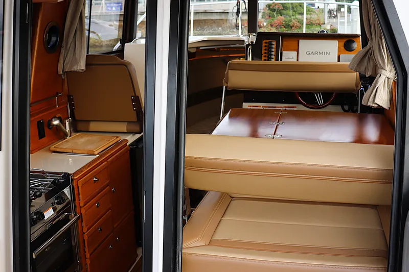 Tail Finn Yacht Photos Pics Interior of 2021 Ranger Tugs R-27, featuring kitchen and seating area with Garmin equipment.