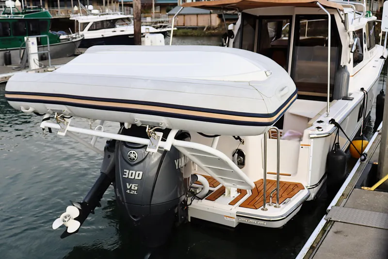 Tail Finn Yacht Photos Pics 2021 Ranger Tugs R-27 with Yamaha 300 V6 outboard motor and inflatable boat at dock.