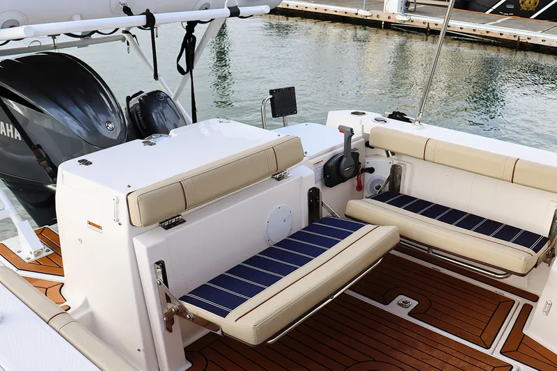 Tail Finn Yacht Photos Pics 2021 Ranger Tugs R-27 boat interior with cushioned seating and Yamaha engine.