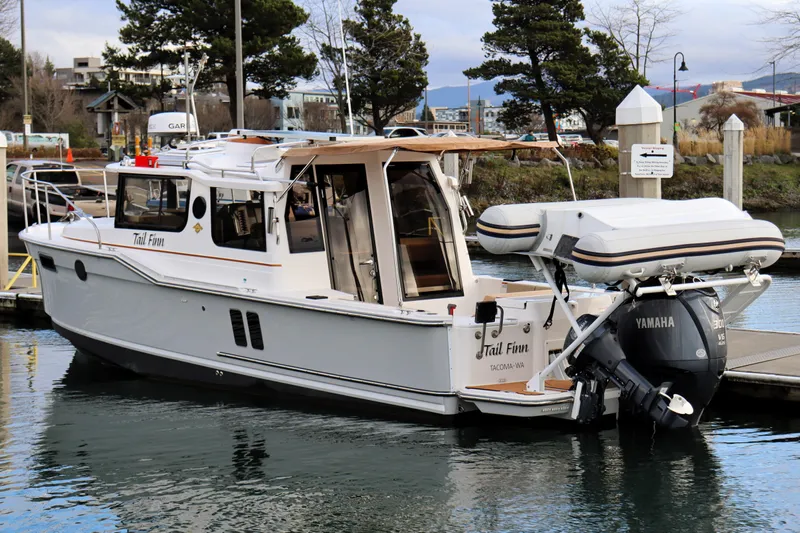 Tail Finn Yacht Photos Pics 2021 Ranger Tugs R-27 boat docked with Yamaha outboard motor, scenic marina background.