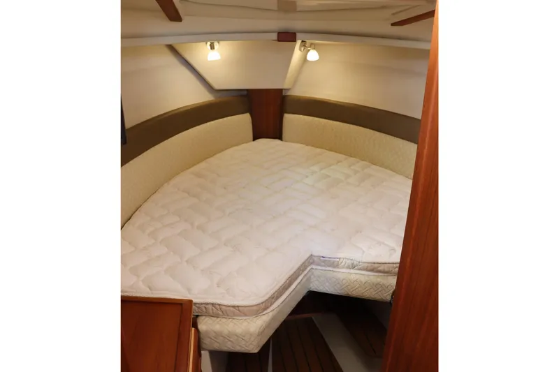 Tail Finn Yacht Photos Pics 2021 Ranger Tugs R-27 cabin interior with cozy bed and warm lighting.