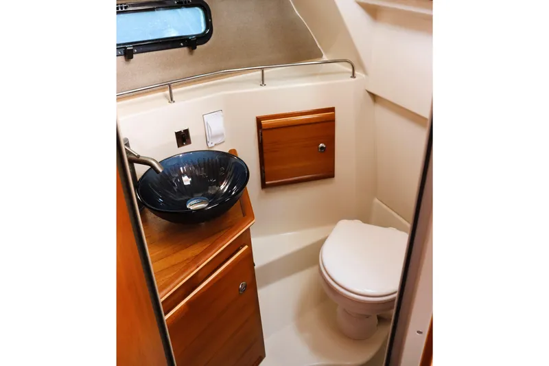 Tail Finn Yacht Photos Pics 2021 Ranger Tugs R-27 boat bathroom with modern sink and wooden cabinetry.