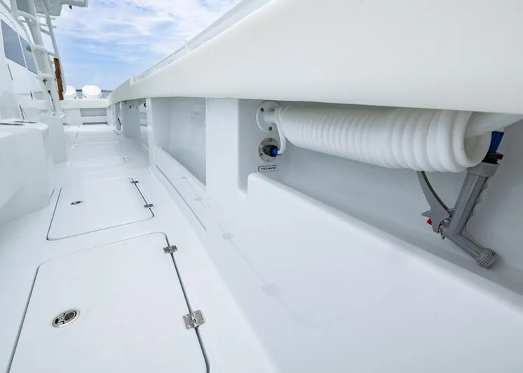  Yacht Photos Pics 2026 Invincible 40 Catamaran deck with storage compartments and coiled hose.