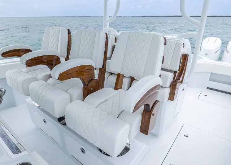  Yacht Photos Pics Luxurious seating on 2026 Invincible 40 Catamaran, featuring white quilted upholstery and wooden accents.