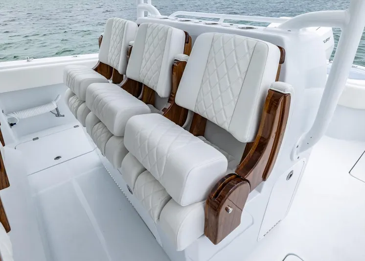  Yacht Photos Pics Luxurious seating on 2026 Invincible 40 Catamaran, featuring white quilted upholstery and wooden accents.