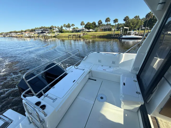 Yacht Photos Pics 2020 Beneteau Antares 9 OB boat on calm water, featuring spacious deck and scenic shoreline view.