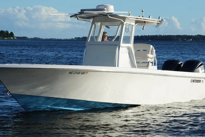  Yacht Photos Pics 2023 Contender 30 Tournament boat cruising on a calm lake under a clear sky.