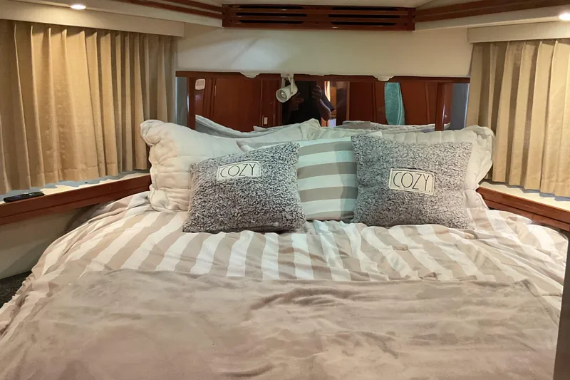  Yacht Photos Pics Cozy bedroom interior of 2000 Carver 530 Voyager Pilothouse with striped bedding and pillows.