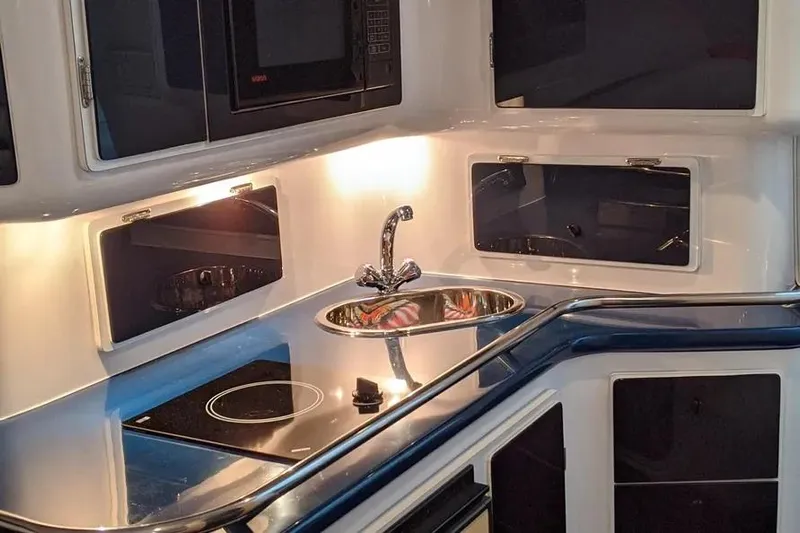  Yacht Photos Pics Modern kitchen area in a 2000 Donzi Daytona 45 boat, featuring a sink and stovetop.