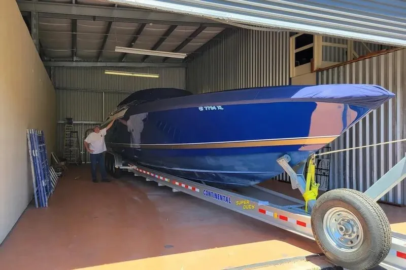  Yacht Photos Pics 2000 Donzi Daytona 45 boat in storage, blue hull, on trailer.