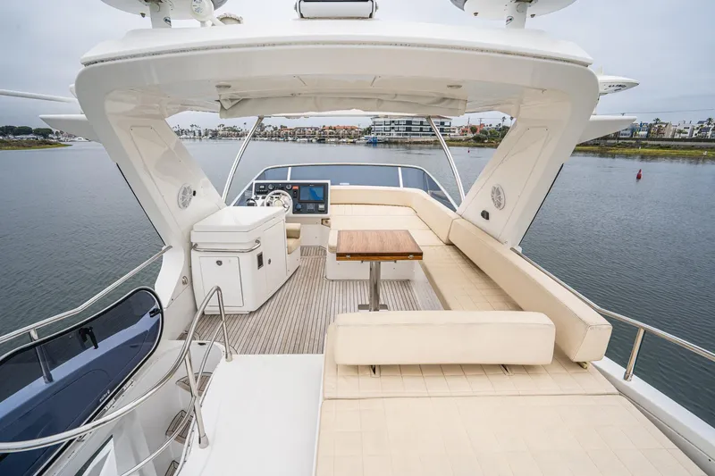 Yacht Photos Pics 2017 Azimut 54 Flybridge yacht with spacious seating and helm, overlooking serene waters.