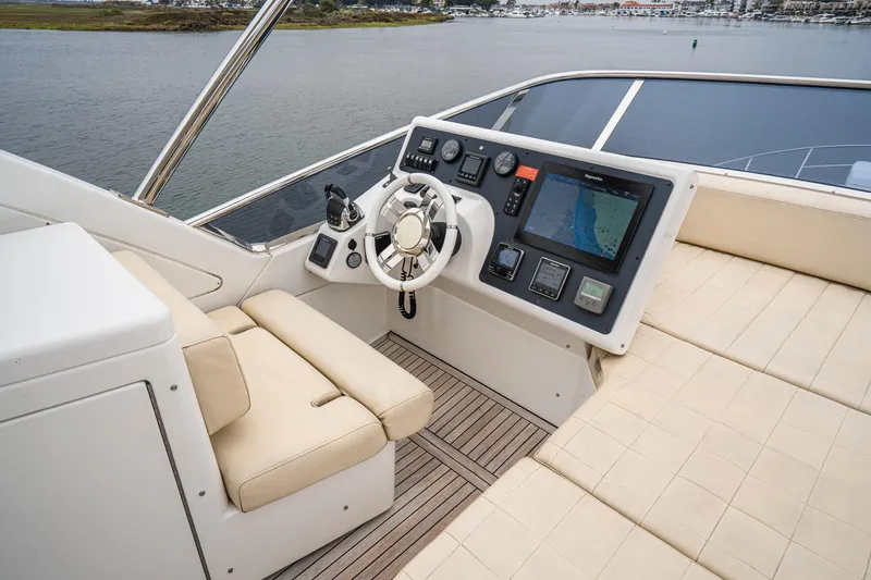  Yacht Photos Pics Flybridge helm of 2017 Azimut 54, featuring modern navigation controls and beige seating.
