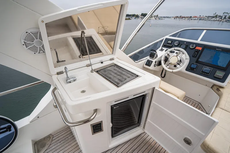  Yacht Photos Pics 2017 Azimut 54 Flybridge yacht helm with sink, grill, and navigation controls.