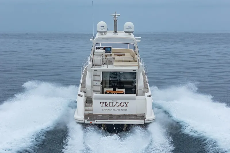  Yacht Photos Pics Azimut 54 Flybridge 2017 yacht cruising on open water, rear view.