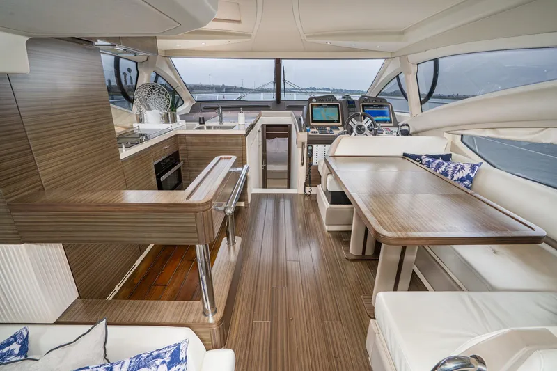 Yacht Photos Pics Luxurious interior of 2017 Azimut 54 Flybridge yacht with modern wood finishes and navigation equipment.