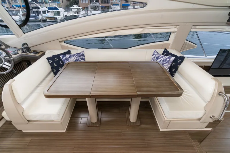  Yacht Photos Pics Luxurious seating area on 2017 Azimut 54 Flybridge yacht with elegant wooden table.