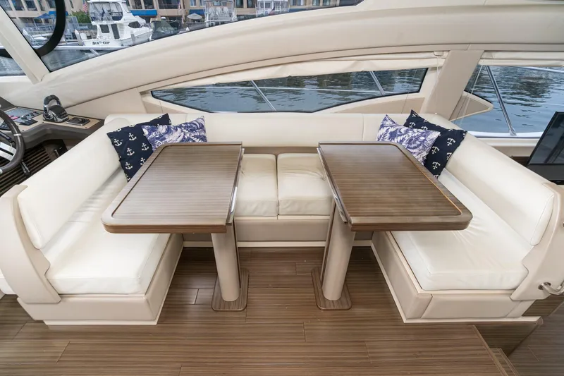  Yacht Photos Pics Luxurious seating area on 2017 Azimut 54 Flybridge yacht with elegant wooden tables.