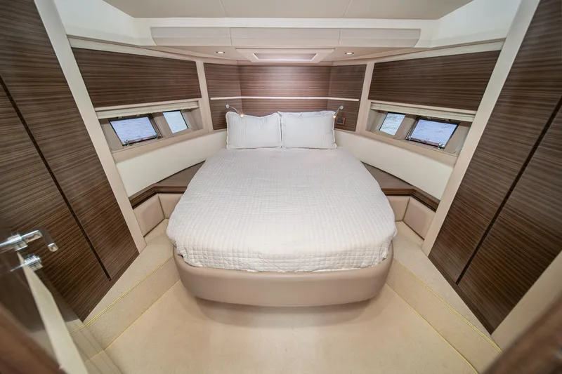  Yacht Photos Pics Luxurious bedroom interior of 2017 Azimut 54 Flybridge yacht with modern wood paneling.