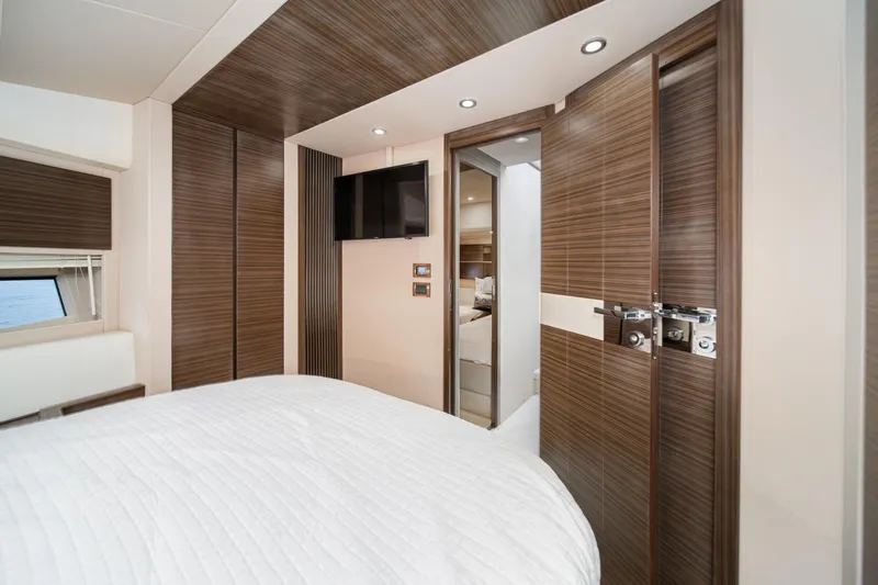  Yacht Photos Pics Luxurious interior of 2017 Azimut 54 Flybridge yacht bedroom with modern wood paneling.