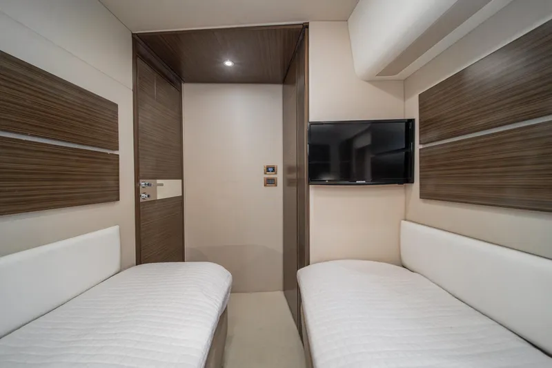  Yacht Photos Pics Interior of 2017 Azimut 54 Flybridge yacht with twin beds and wall-mounted TV.