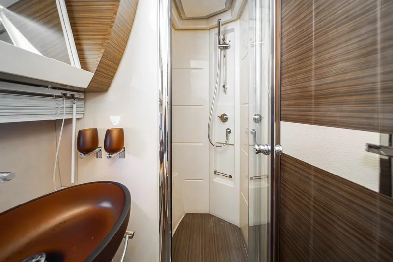  Yacht Photos Pics Luxurious bathroom in 2017 Azimut 54 Flybridge yacht with modern fixtures and wood accents.