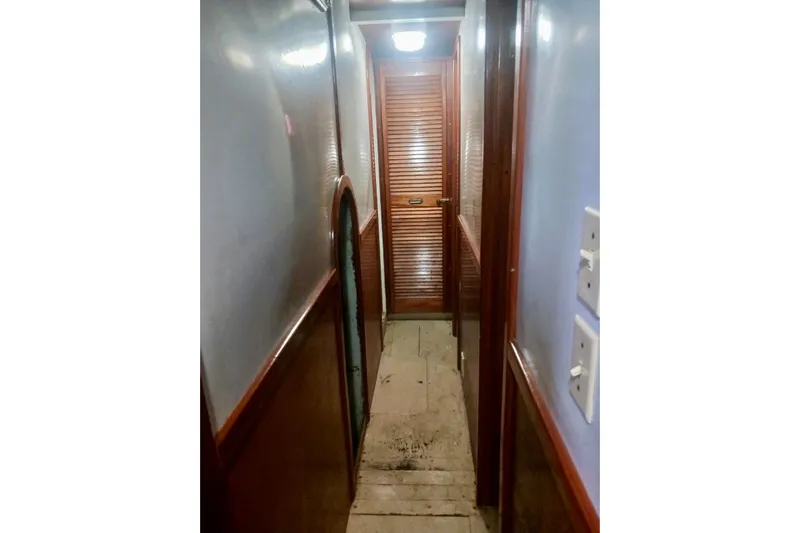 Cloud Chaser Yacht Photos Pics Narrow hallway inside 1997 Hike Metal Products 67-foot steel full-keel ketch, featuring wooden paneling.