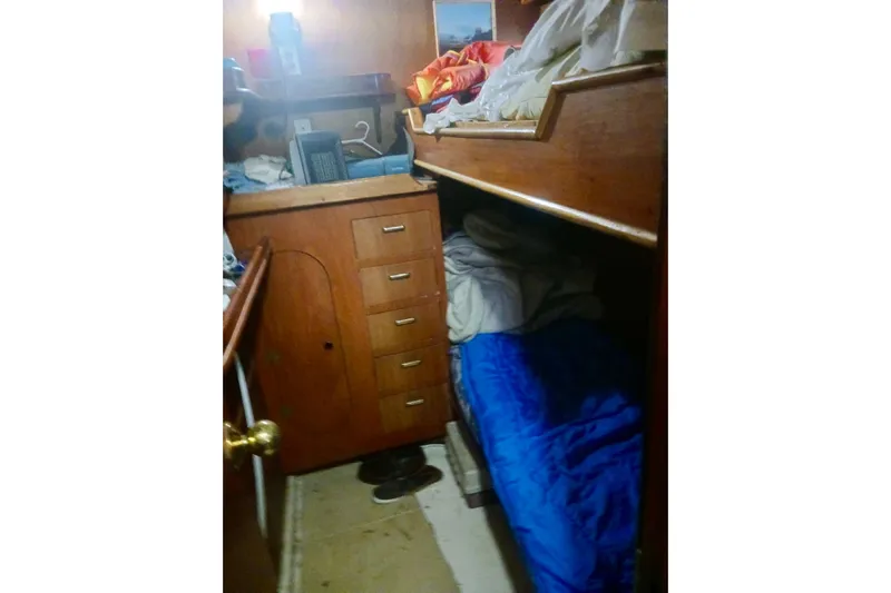 Cloud Chaser Yacht Photos Pics Interior cabin of 1997 Hike Metal Products 67-foot steel ketch, featuring wooden cabinetry and bunk bed.